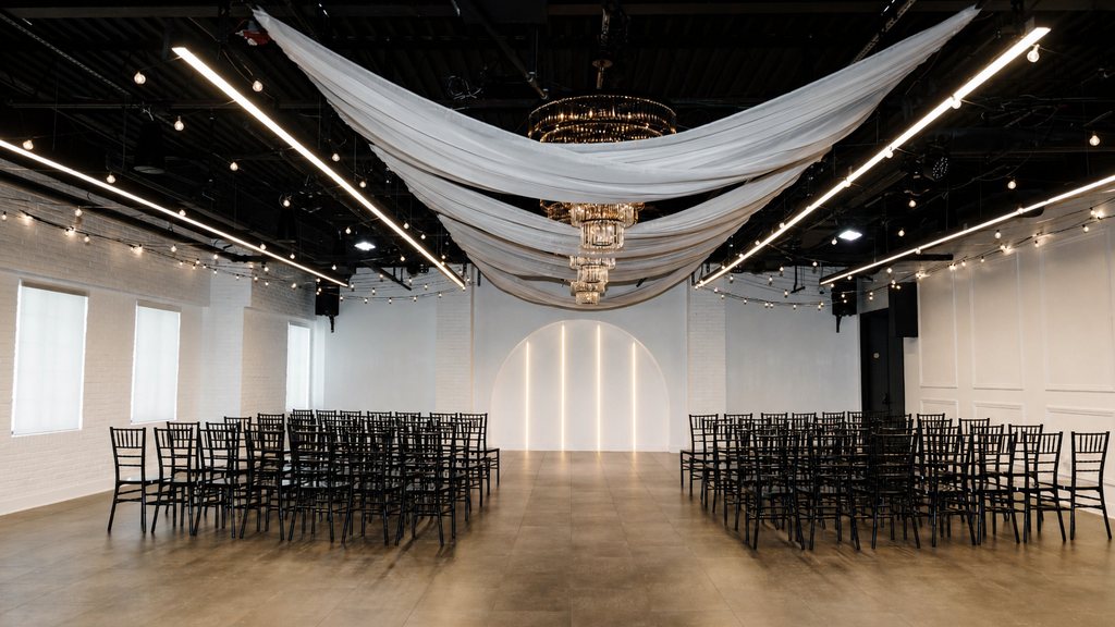 The Trellis 925 main hall set for a ceremony beneath draped fabric and chandeliers