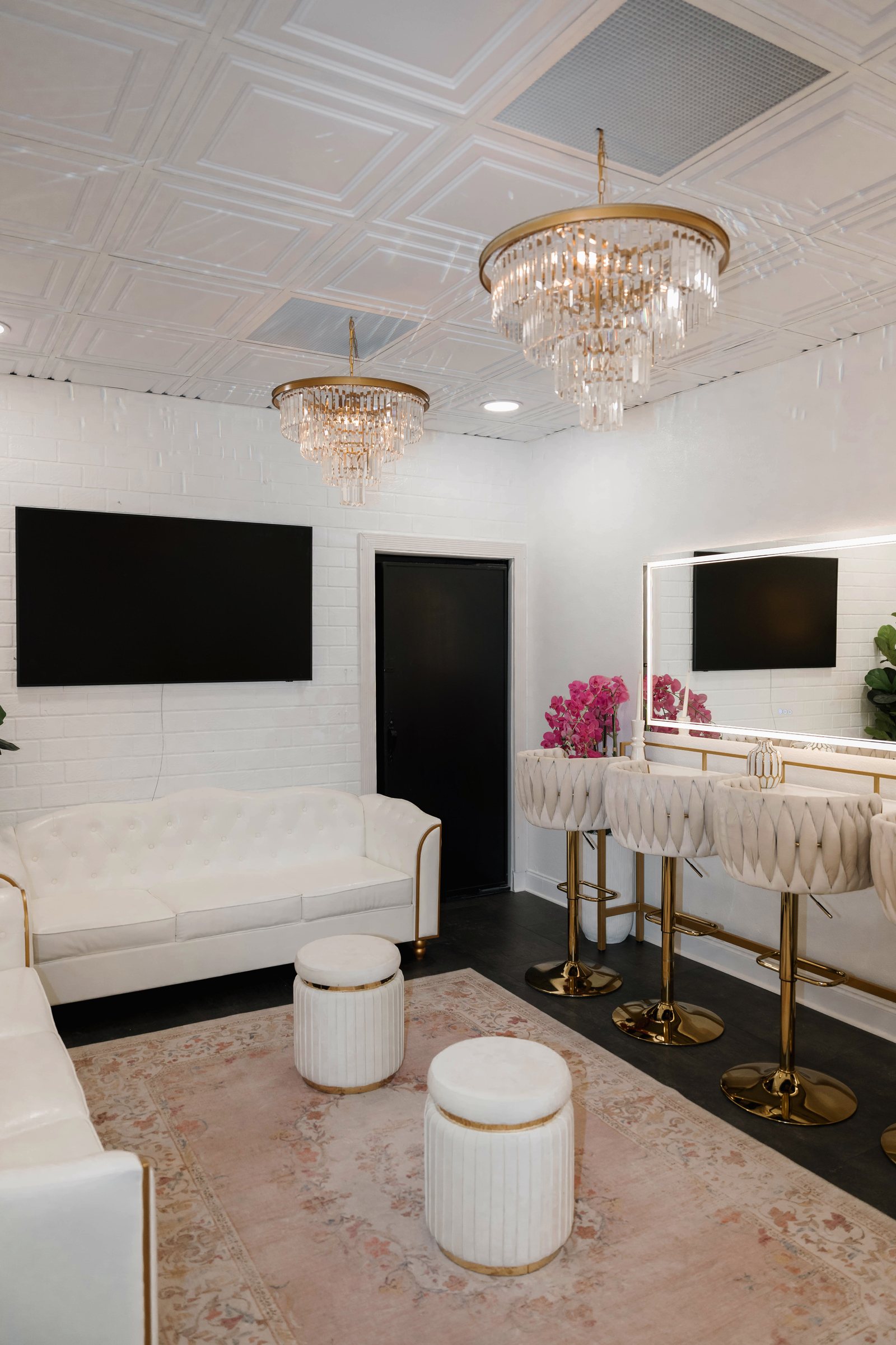 The white VIP Suite at Trellis 925 with chandeliers and lounge seating