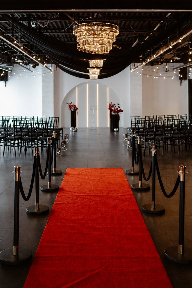 A red carpet aisle beneath the chandeliers at Trellis 925