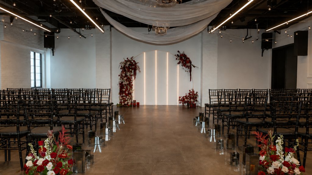 A wedding ceremony set with deep red florals at Trellis 925