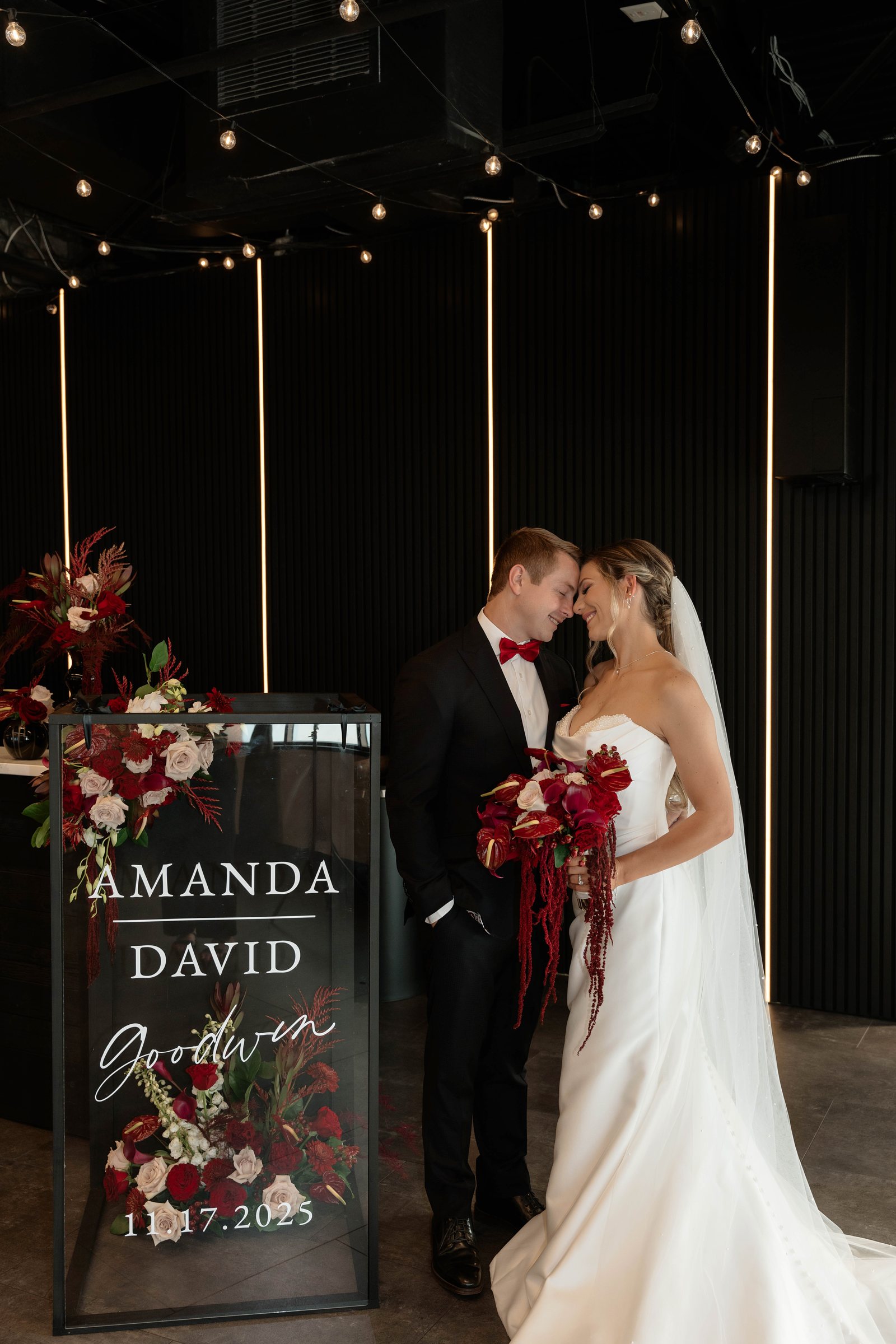 A couple beside their wedding signage at Trellis 925